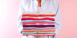 Woman with stack of folded shirts