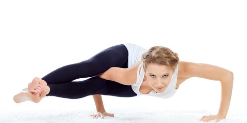 Slender young woman doing yoga exercise. Isolated over white background.